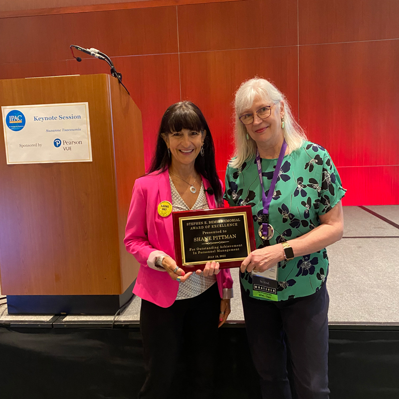 Shane Pittman (right) poses with Suzanne Tsacoumis after receiving the 2022 Bemis Award