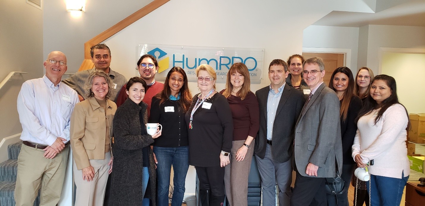 people-2 Group of HumRROvians in the office in front of the HumRRO logo sign